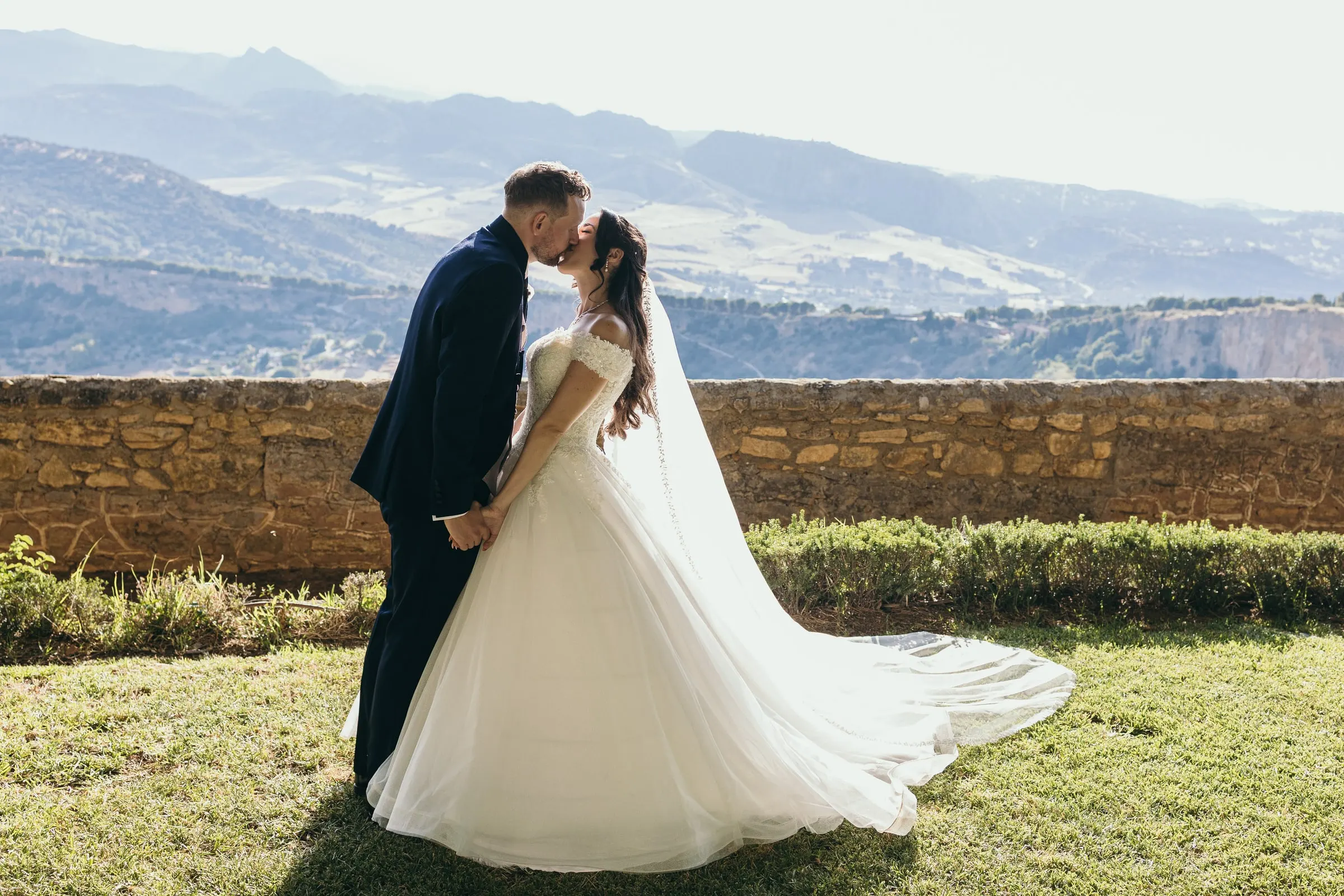 Un beso junto al viejo muro de piedra, con las montañas de la Serranía de Ronda detrás