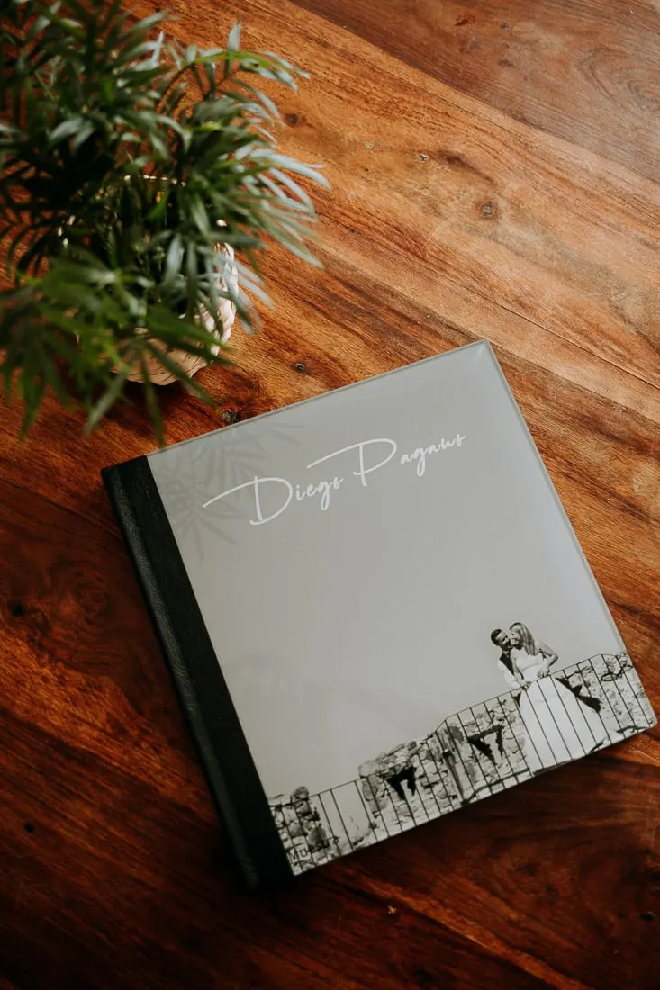 Álbum de boda fine art cerrado, con portada gris y una foto impresa, sobre una mesa de madera, Picart