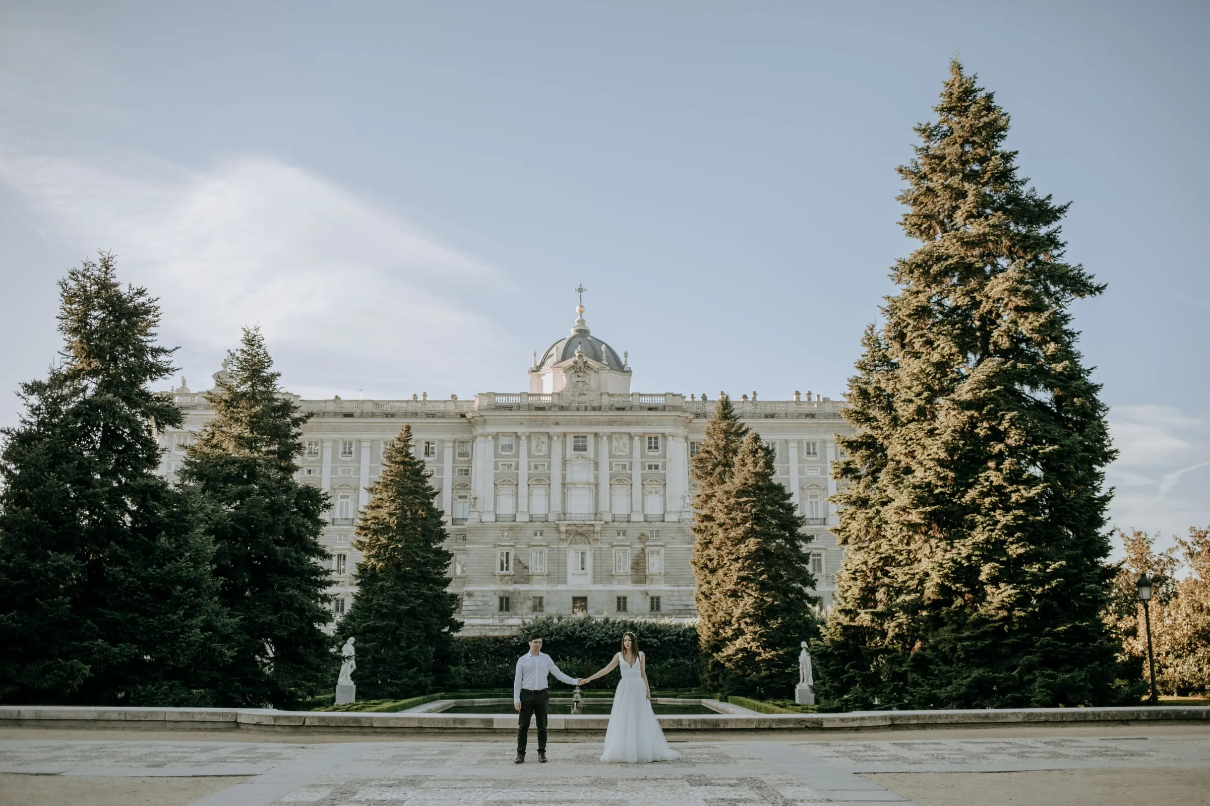 Los novios de la mano, pequeños ante el Palacio Real de Madrid