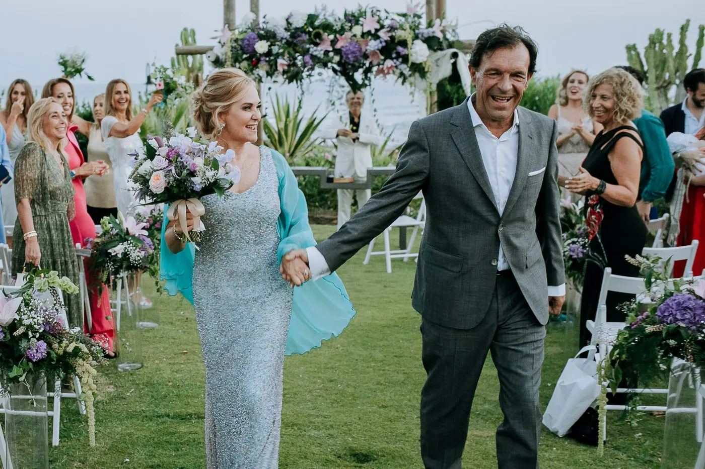 Los recién casados ríen por el pasillo entre los vítores de los invitados, Tikitano